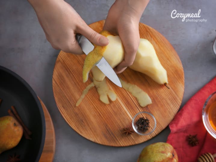 Peeling pears over wooden board