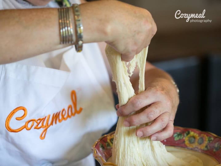 A baker kneading and shaping dough during a hands on workshop