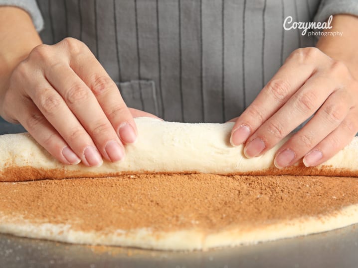 A baker preparing breakfast cakes and rolling dough with precision