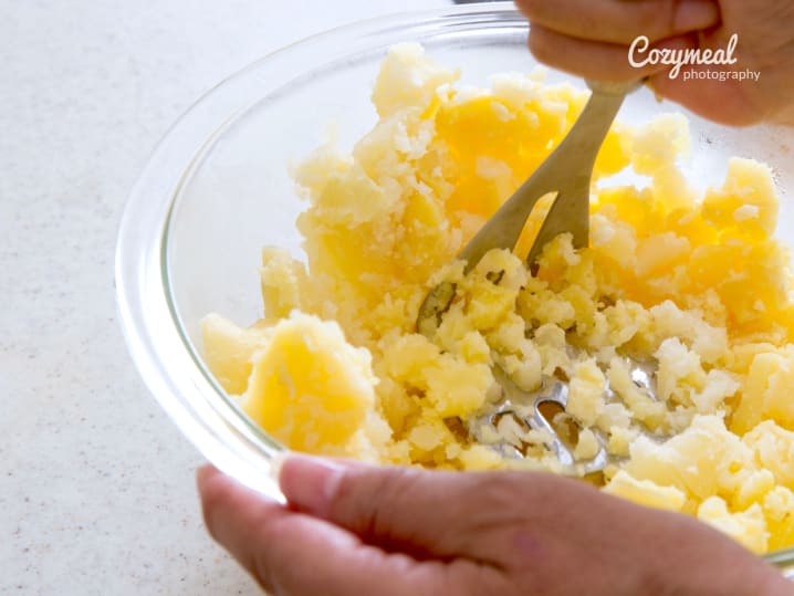 A bowl of mashed potatoes being prepared