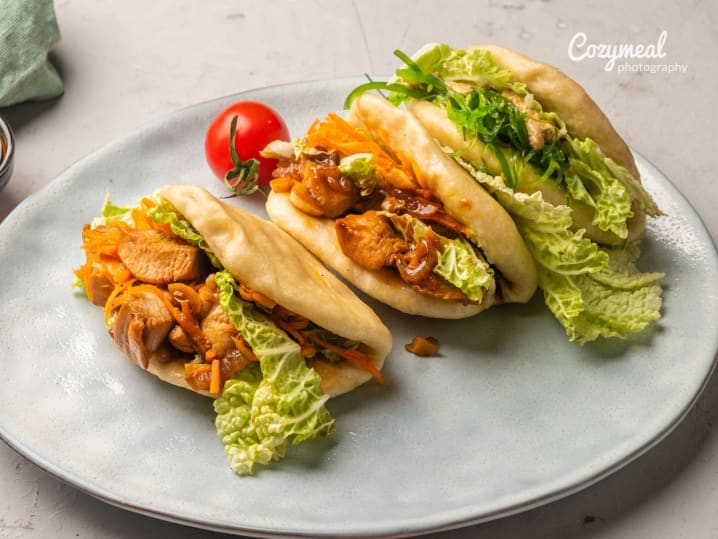 plated bao buns filled with crispy chicken and fresh lettuce leaves on a grey plate