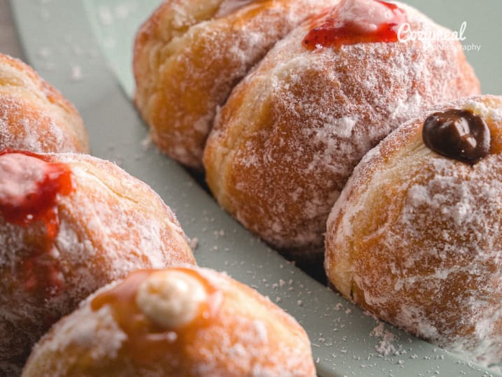 Bomboloni donuts with assorted fillings â€“ Italian bomboloni donuts filled with chocolate, cream, and fruit jam, coated in sugar.