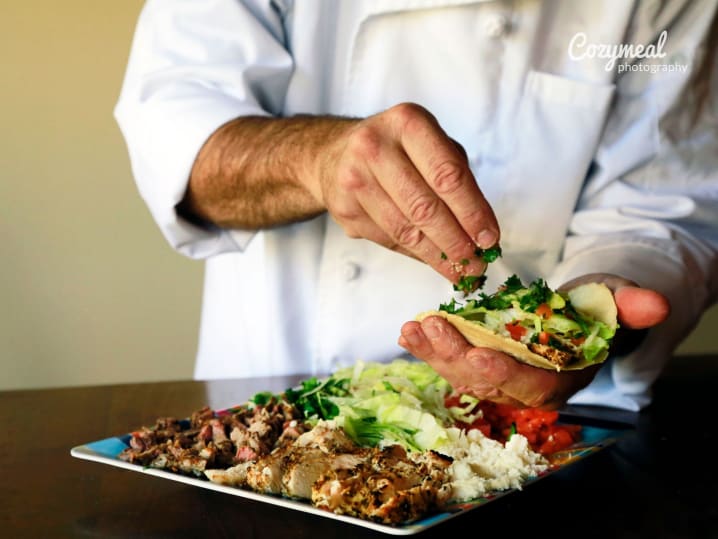 Chef assembling street tacos with fresh ingredients