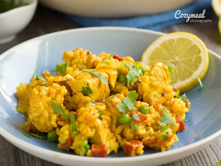 traditional chicken and chorizo paella garnished with lemon slices