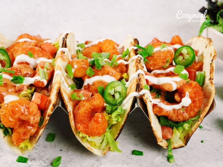 Crispy shrimp tacos with sauce and greens