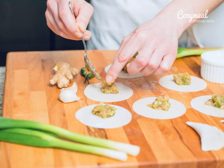 Dumpling filling being added to wrappers