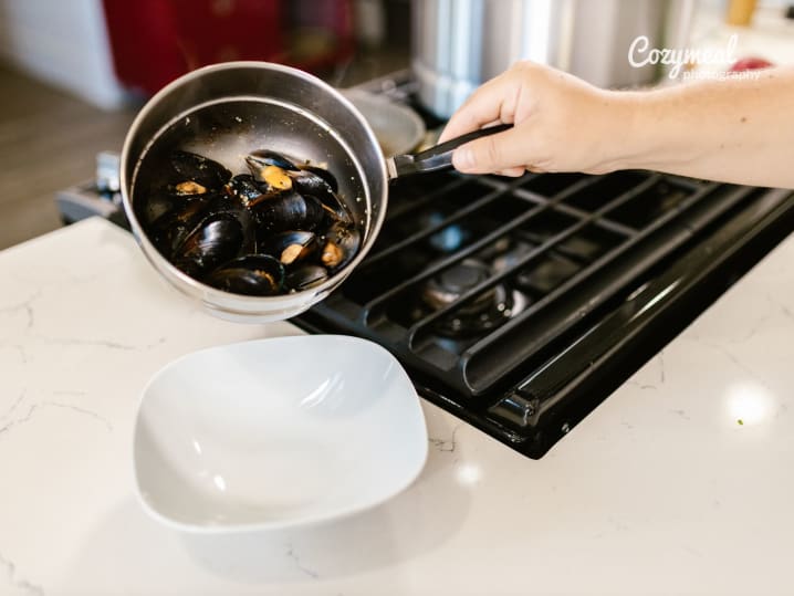 Hand Holding Pot with Boiled Mussels