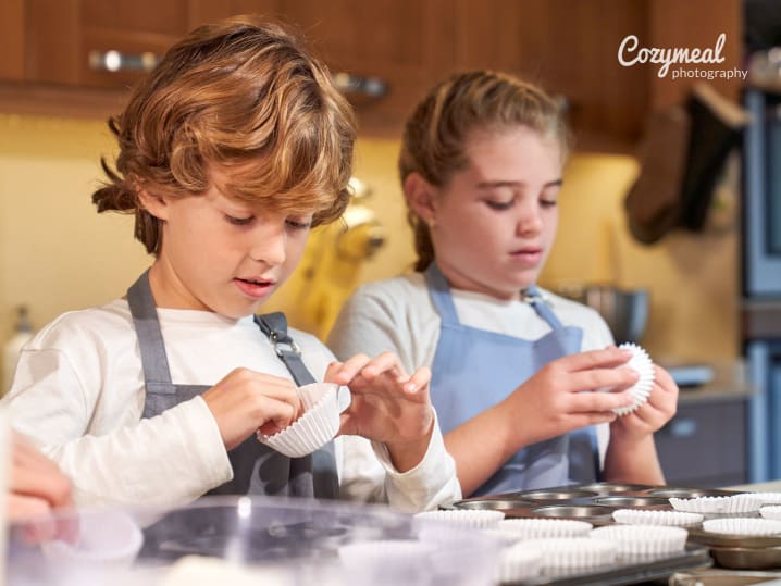 a young boy and a girl preparing cupcakes
