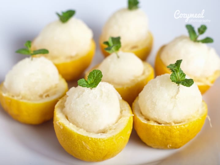 lemon sorbet elegantly served in hollowed lemon cups garnished with fresh mint leaves