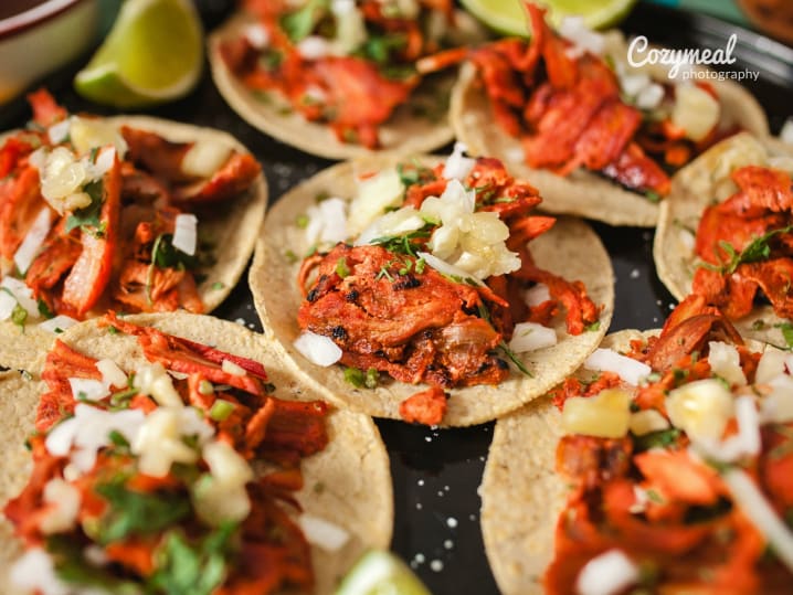 Tacos al pastor topped with onion and cilantro