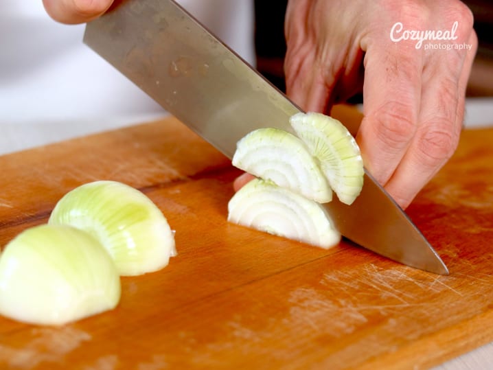 a chef slicing onions for french onion soup