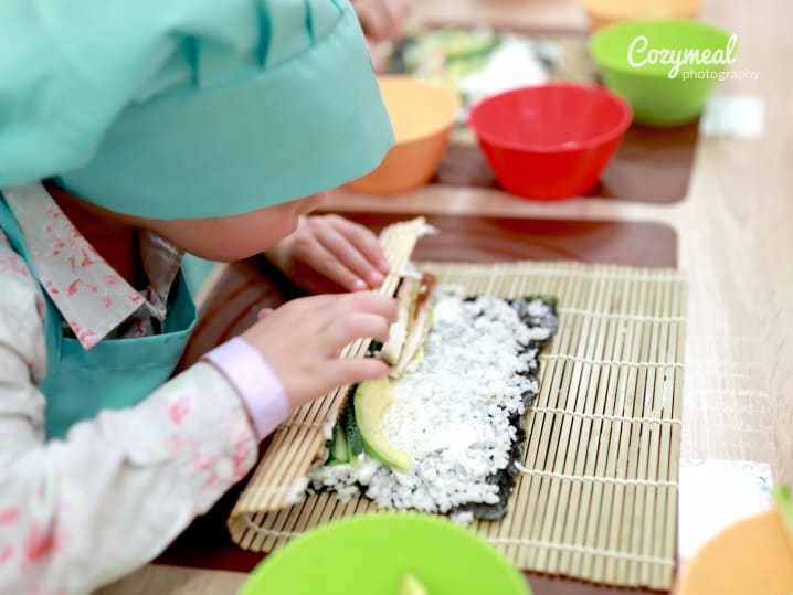 a kid making homemade sushi