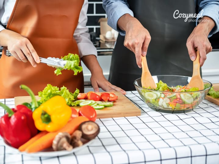 a couple preparing salad together