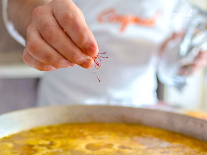 chef adding saffron to paella