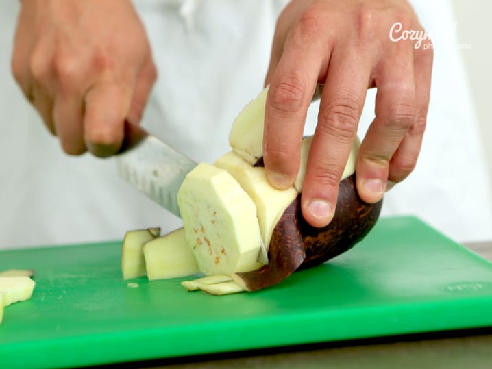 chef or person slicing eggplant