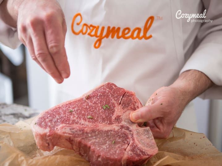 chef pouring salt on steak