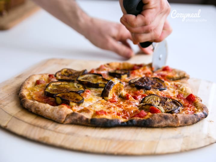 chef slicing an eggplant pizza
