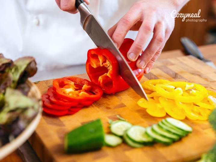 chef slicing red bell peppers