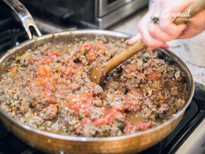 chef stirring bolognese sauce