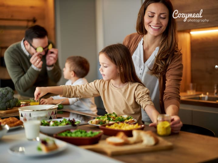 cooking together as a family with kids setting up a table for festive dinner