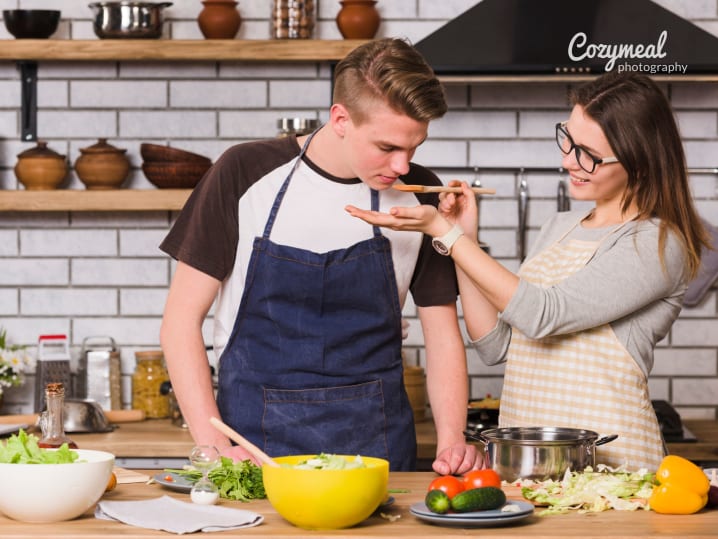 couple cooking together and tasting the food as they go