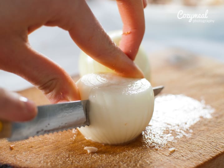 close-up of chef slicing fresh onion on cutting board