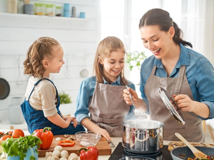 daughters are cooking alongside their mother