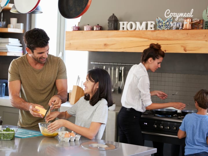 family preparing batter together in the kitchen