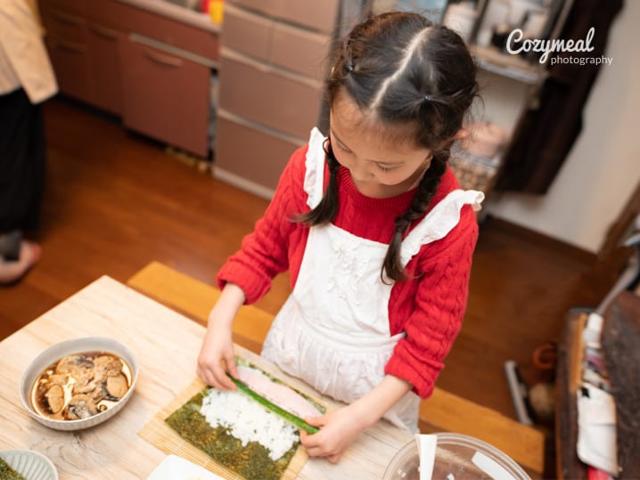 kid making sushi rolls