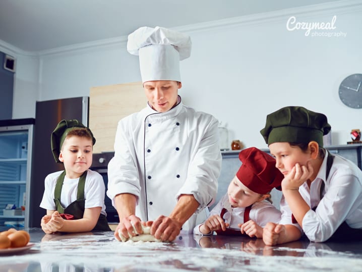 Chef teaching three young boys how to make fresh pasta