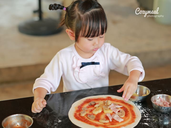 little girl making homemade pizza