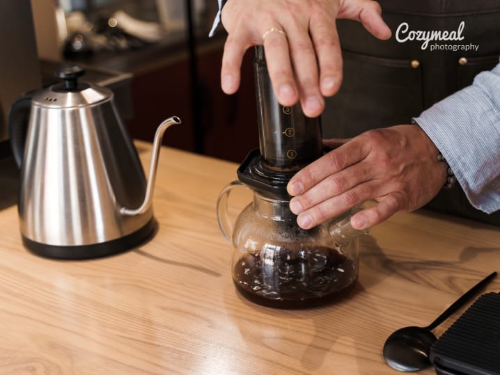 person making aeropress coffee