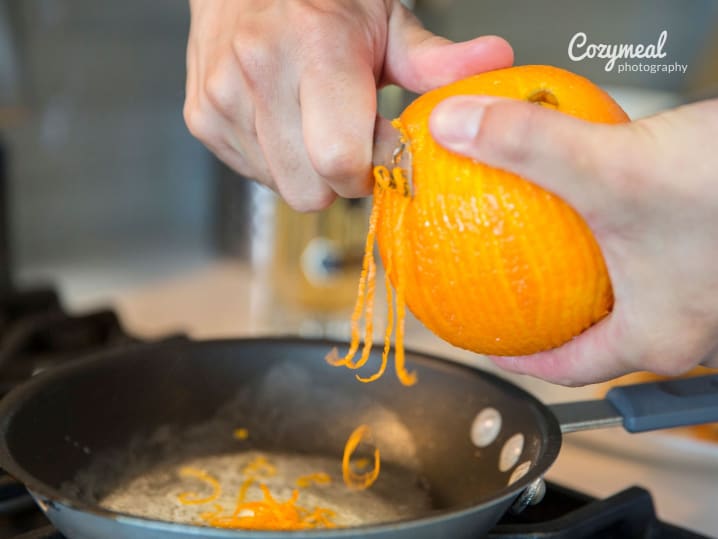 chef zesting orange into skillet while cooking