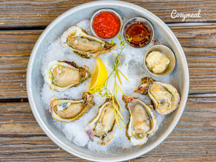 oysters on the half shell with cups of sauce