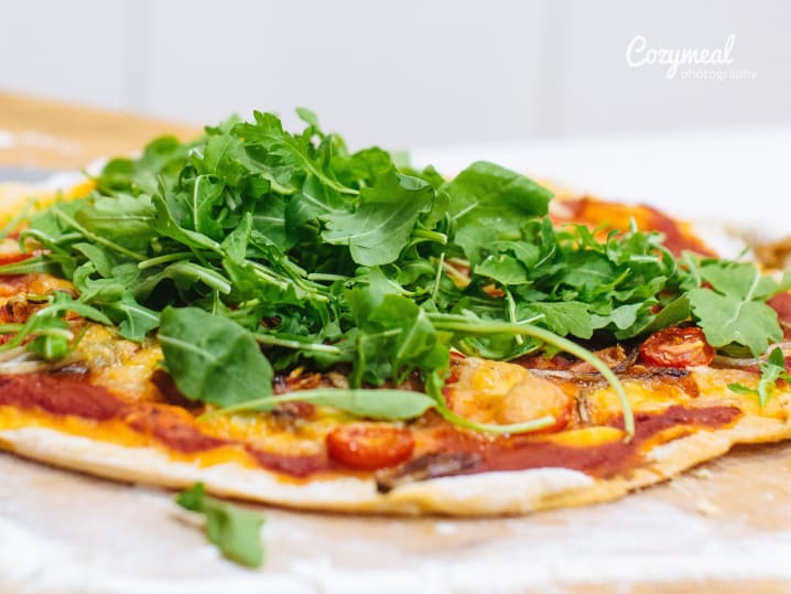 handmade pizza topped with arugula salad