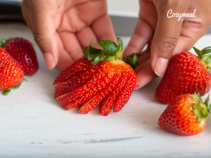 picking a thinly sliced strawberry