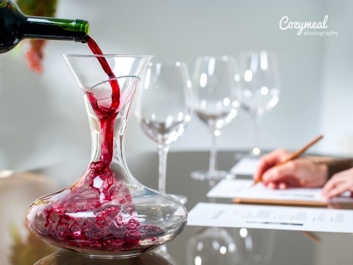 pouring red wine into a wine decanter