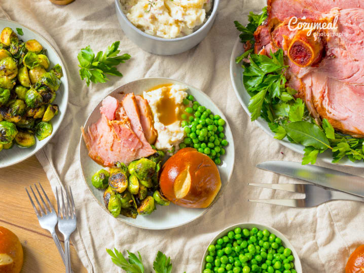 festive holiday menu with baked ham brussels sprouts and dinner rolls