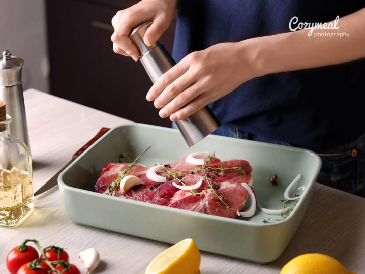 close-up of chef seasoning raw steak in kitchen