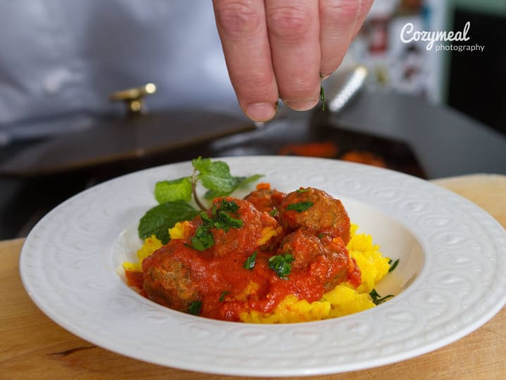 seasoning meatballs in marinara sauce