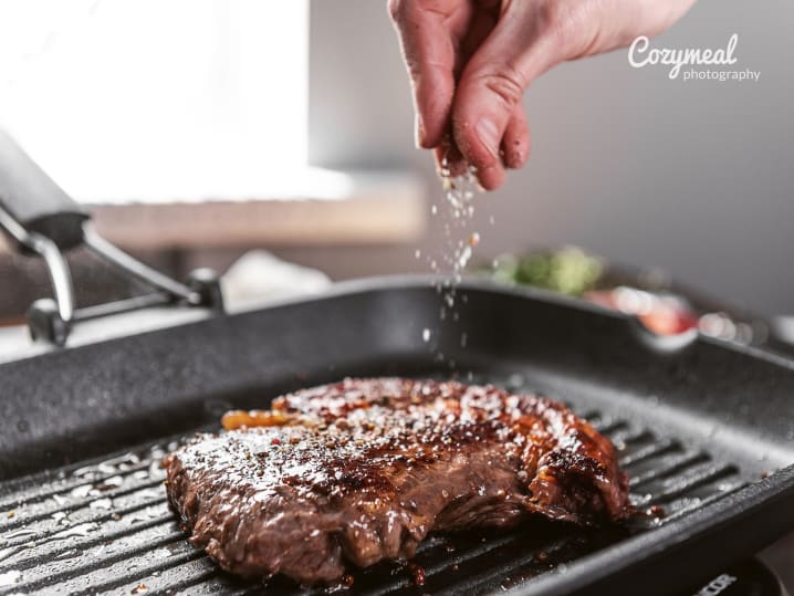 seasoning steak on a grill pan