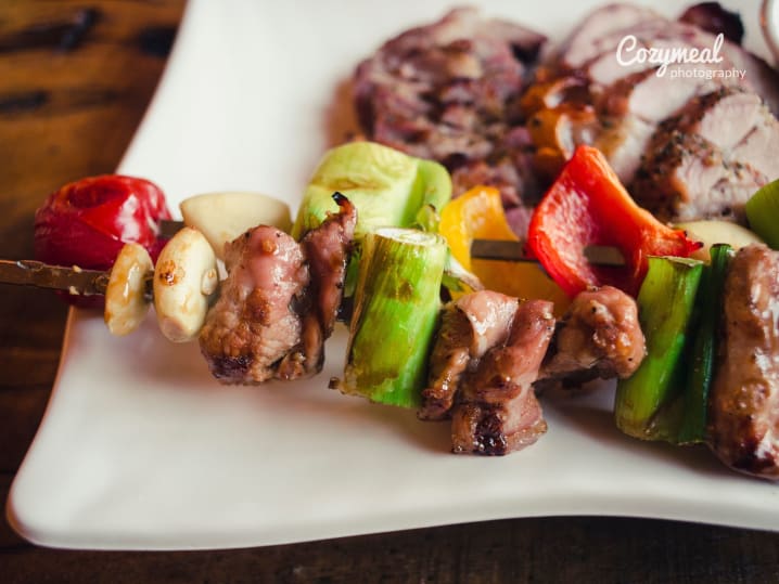 skewered meat and vegetables on a white plate