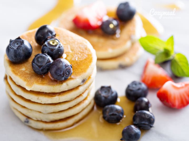 stack of buttermilk pancakes and berries with syrup