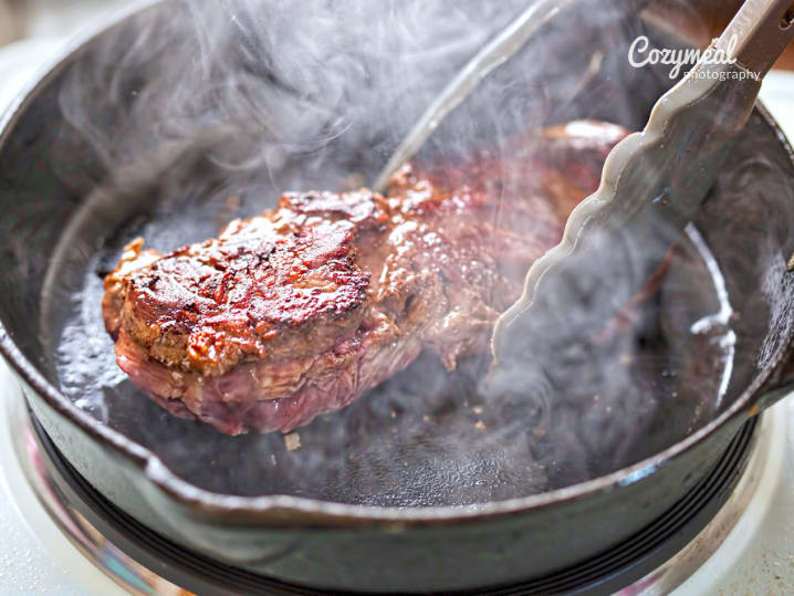 steak cooking in a cast iron skillet