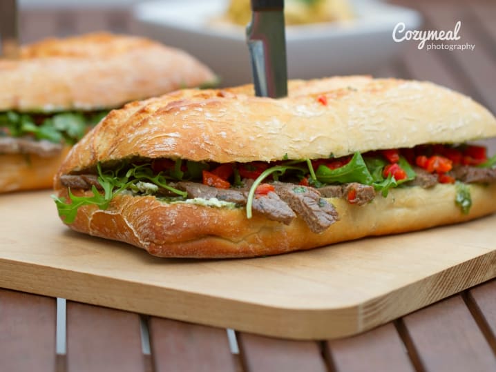 steak sandwich with a knife through it