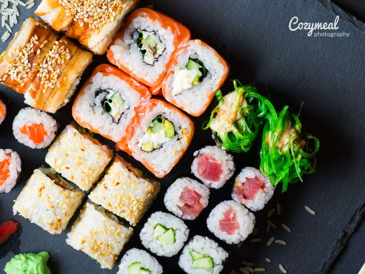 sushi rolls and nigiri on a black slate tray