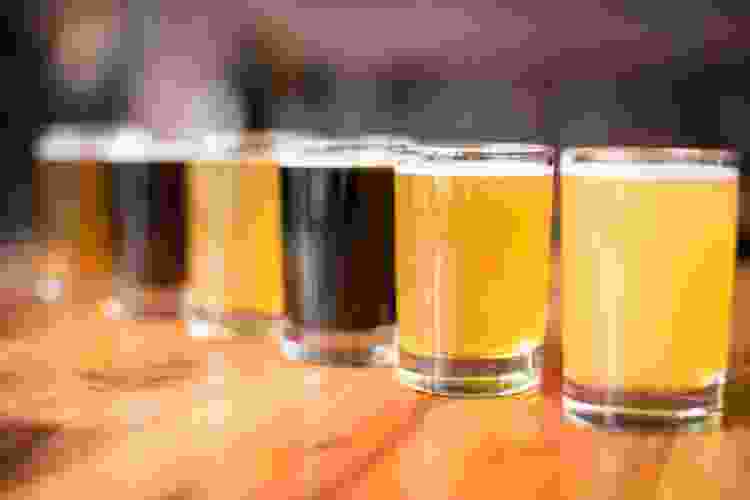 a flight of different beers in a row