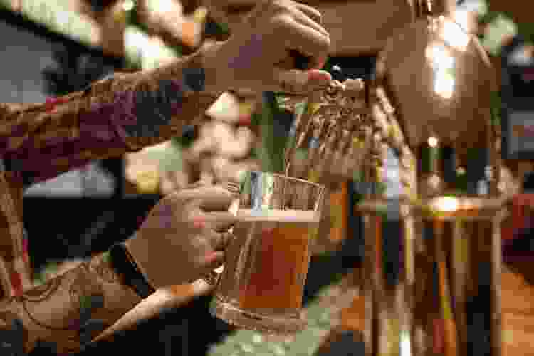 brewmaster pouring a pint of beer at a brewery