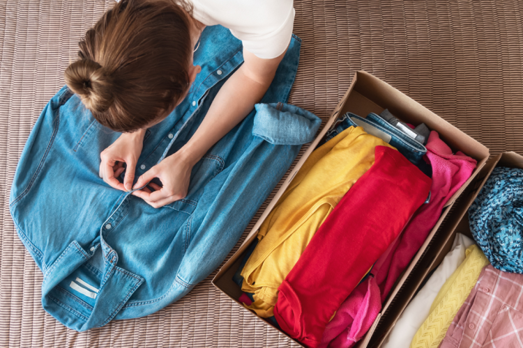 girl folding clothing for a clothes swap