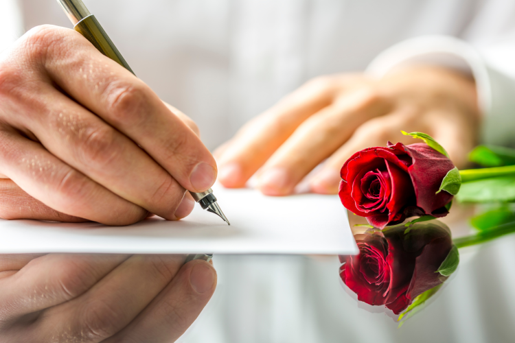 hand writing love letter on paper with pen